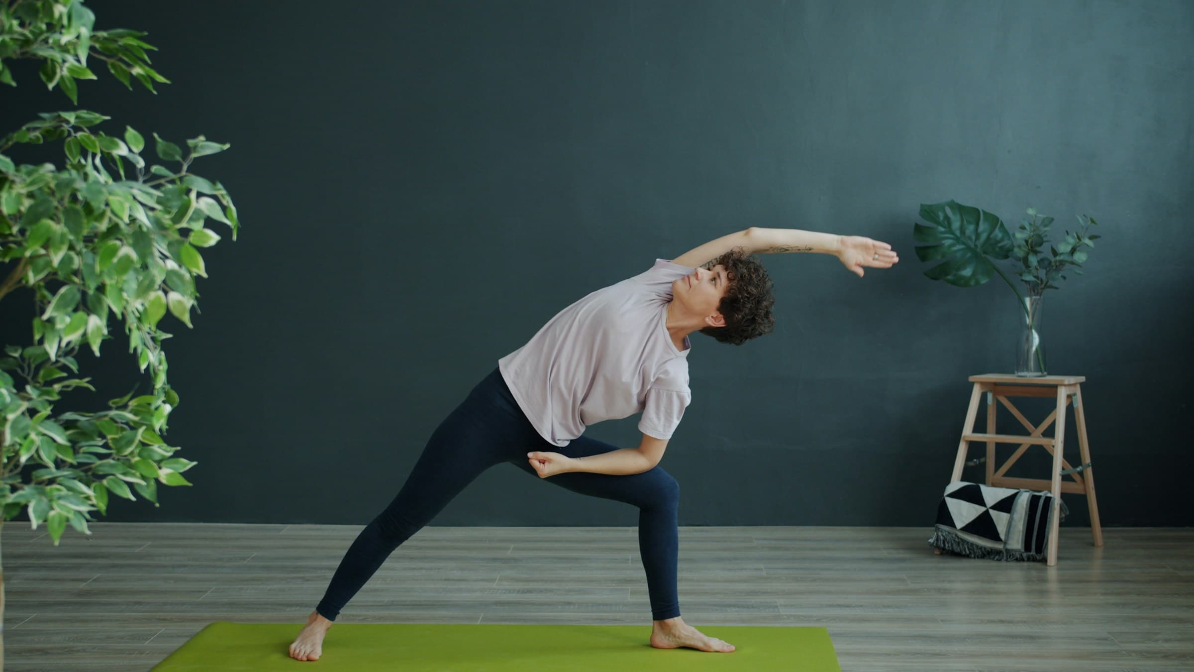A yoga practitioner reaching through a side-body stretch